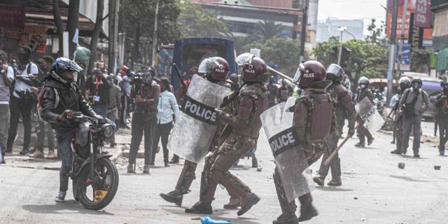 Police officers halt a motor bike rider during the anti finance 2024 finance bill in Kenya. Photo Frank Omondi