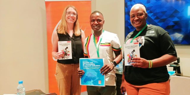 A picture of FIFAfrica24 panelist holding copies of Best Practices For Digital Inclusion of People With Disability In Kenyan Community Networks.